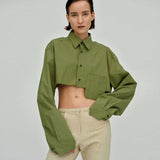 Woman wearing a green cropped button-down shirt with beige pants