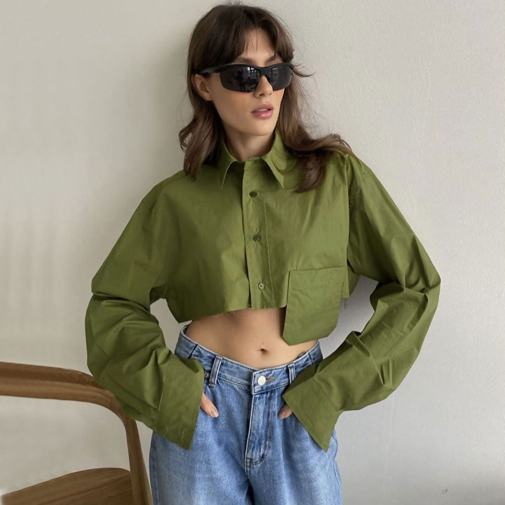 Woman wearing a green cropped button-down shirt with blue jeans and sunglasses