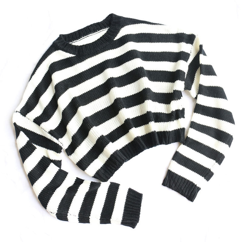 A black and white striped cropped sweater laid flat on a white background, showing the front.
