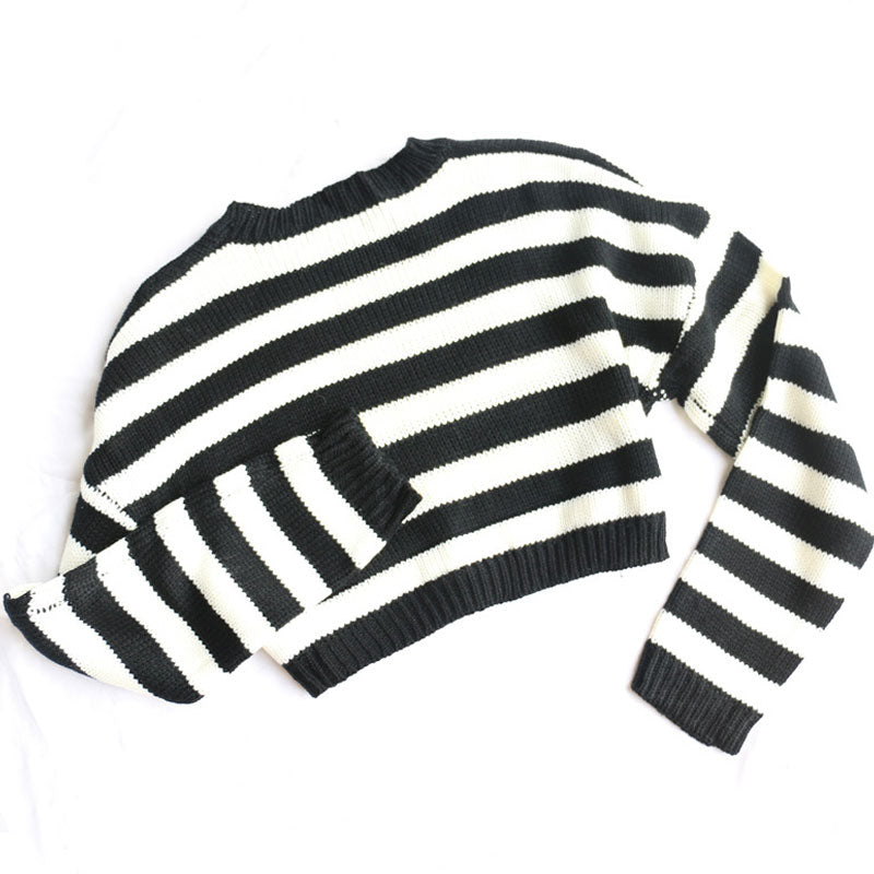A black and white striped cropped sweater laid flat on a white background, showing the back.