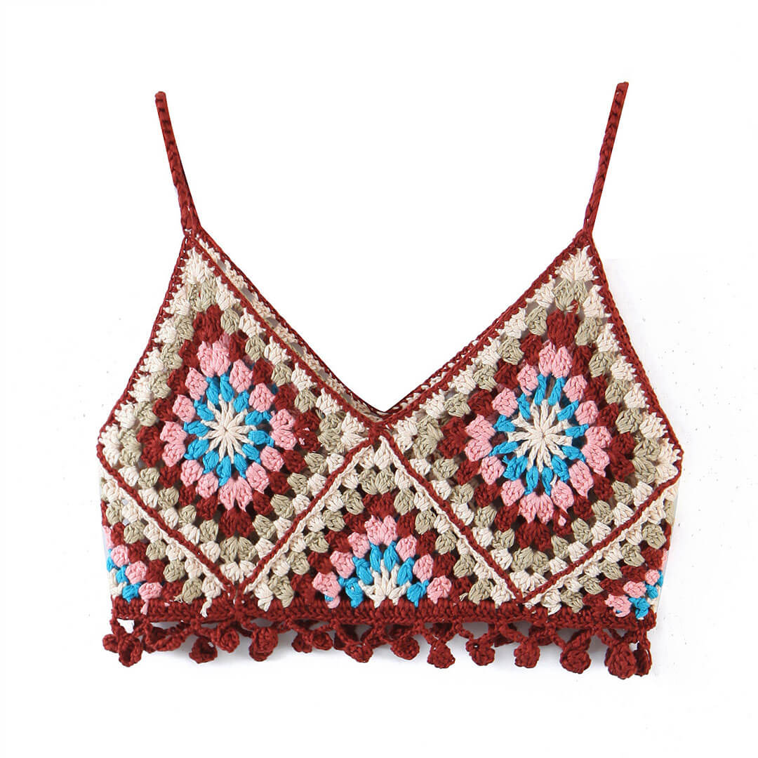 A close-up of a colorful crochet crop top with a granny square pattern and fringe hem.