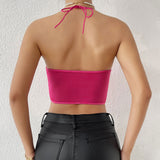 Back view of a woman wearing a fuchsia halter neck corset top.