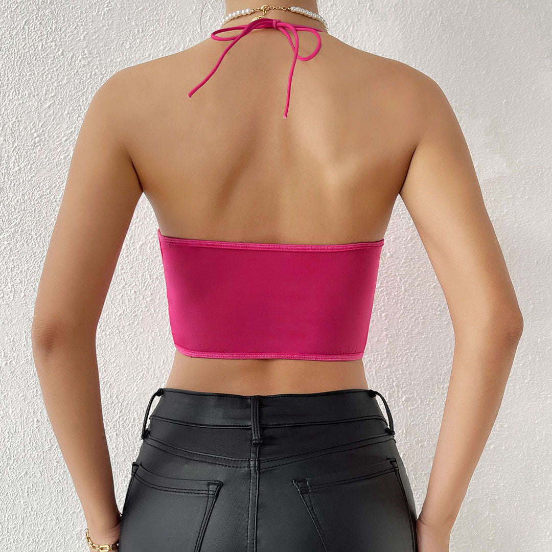 Back view of a woman wearing a fuchsia halter neck corset top.