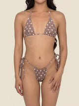 A woman wearing a brown bikini with white polka dots.