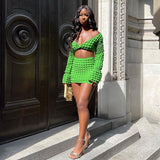 A woman in a green textured two-piece outfit poses outdoors.