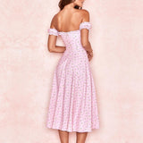 Back view of a woman wearing a pink floral off-the-shoulder midi dress with a sweetheart neckline and ruffled trim, standing against a pink background.