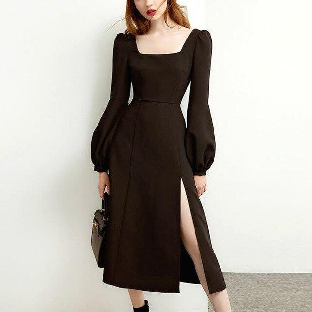 Close-up of a woman wearing a black midi dress with a square neckline and puff sleeves.