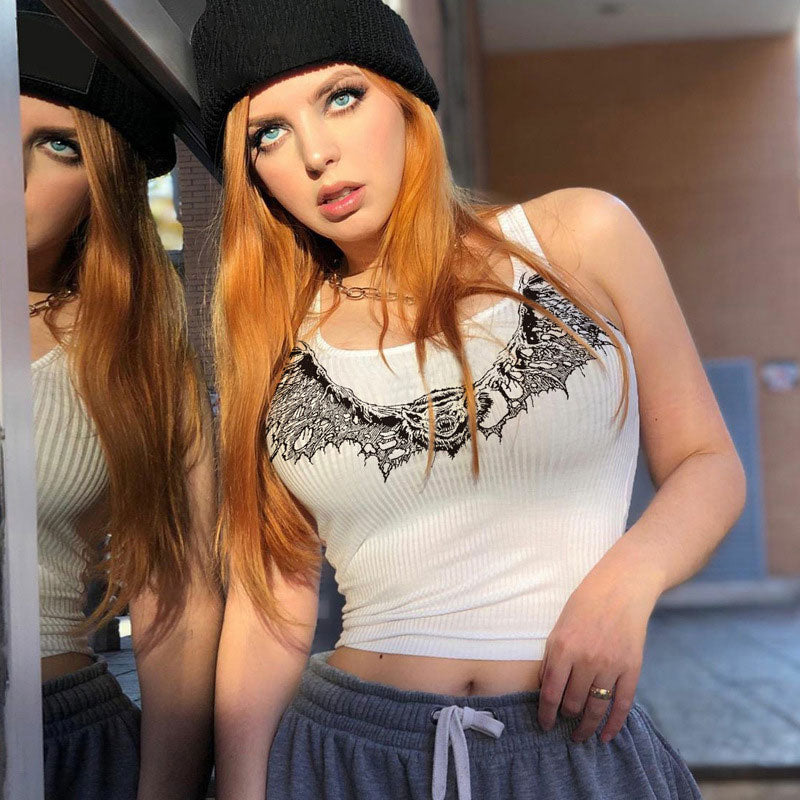 woman with red hair wearing a white graphic print crop top and grey sweatpants