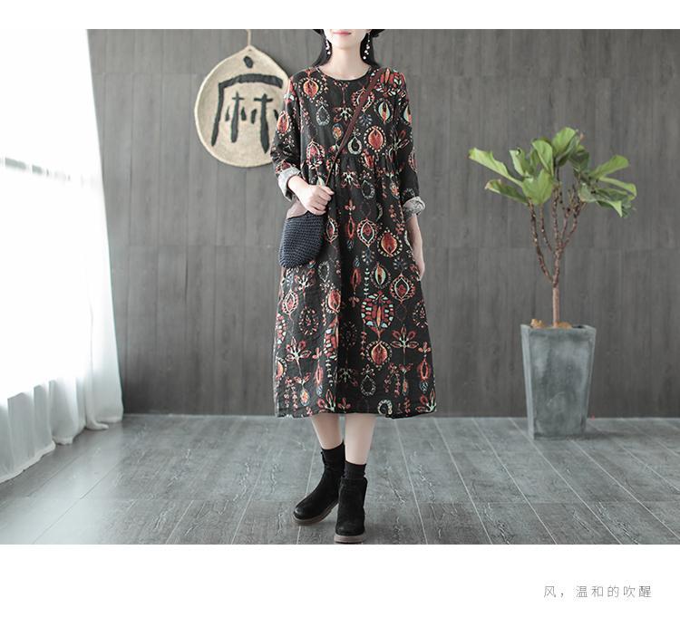 Woman wearing a black floral print midi dress with a black crossbody bag and black boots