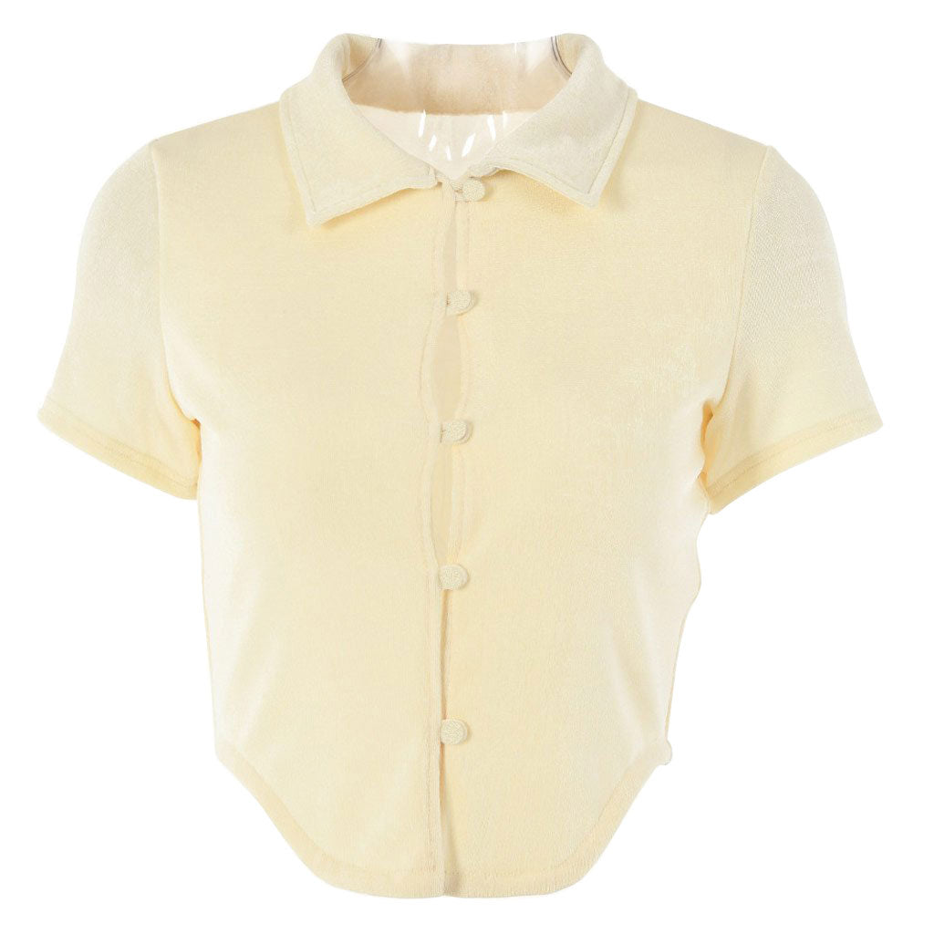 A cream-colored cropped collared shirt with short sleeves and button-up front is displayed on a white background.