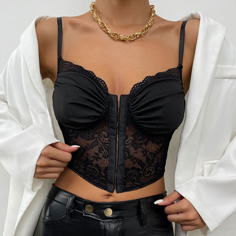Woman wearing a black lace and ruched corset top with a white blazer and black leather pants, accessorized with a gold chain necklace.