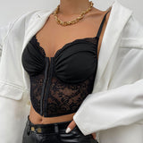 Close-up of a woman's torso showing a black lace and ruched corset top with a white blazer and gold necklace.