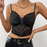Front view of a woman in a black lace and ruched corset top, white blazer, and black leather pants.
