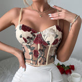 Woman posing with hands on hips wearing a cream corset top with floral embroidery
