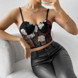 Woman wearing a black floral embroidered corset top and black leather pants.