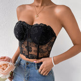 Close-up of a woman in a black floral lace corset top and blue jeans.