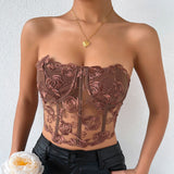 woman wearing a brown floral embroidered strapless corset top with black leather pants and a gold heart necklace