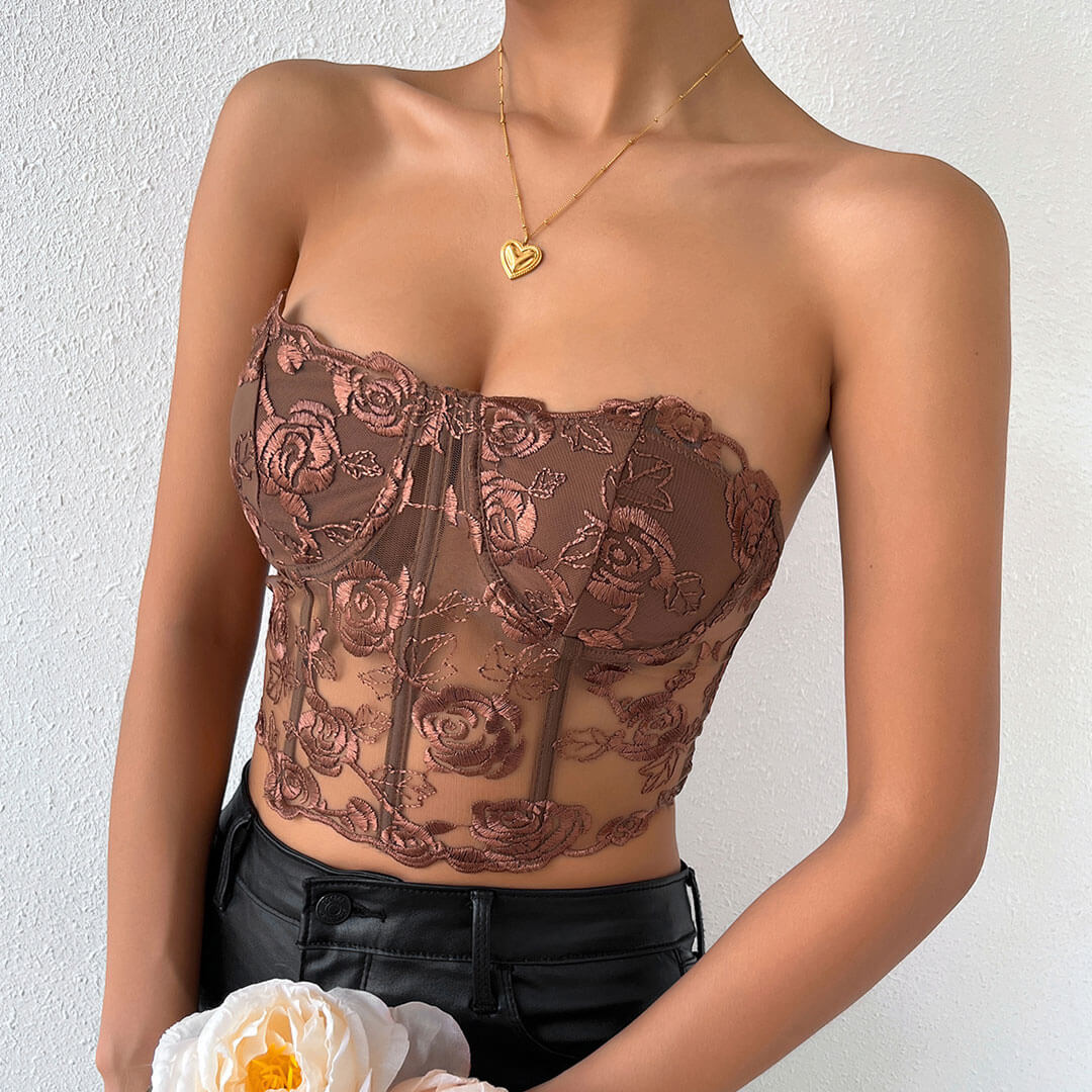 close-up of a woman's torso wearing a brown floral embroidered corset top