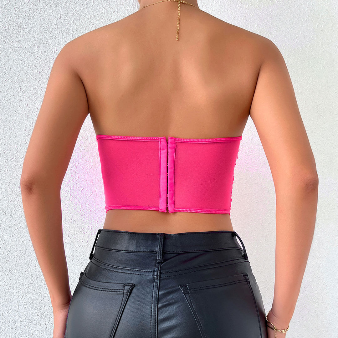 Back view of a woman in a pink lace corset top, showing the hook-and-eye closure.