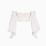 White off-the-shoulder crop top with ruffled neckline and billowy sleeves, front view, on white background