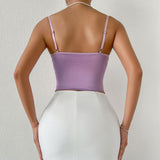 back view of a woman wearing a purple satin corset top and a white skirt