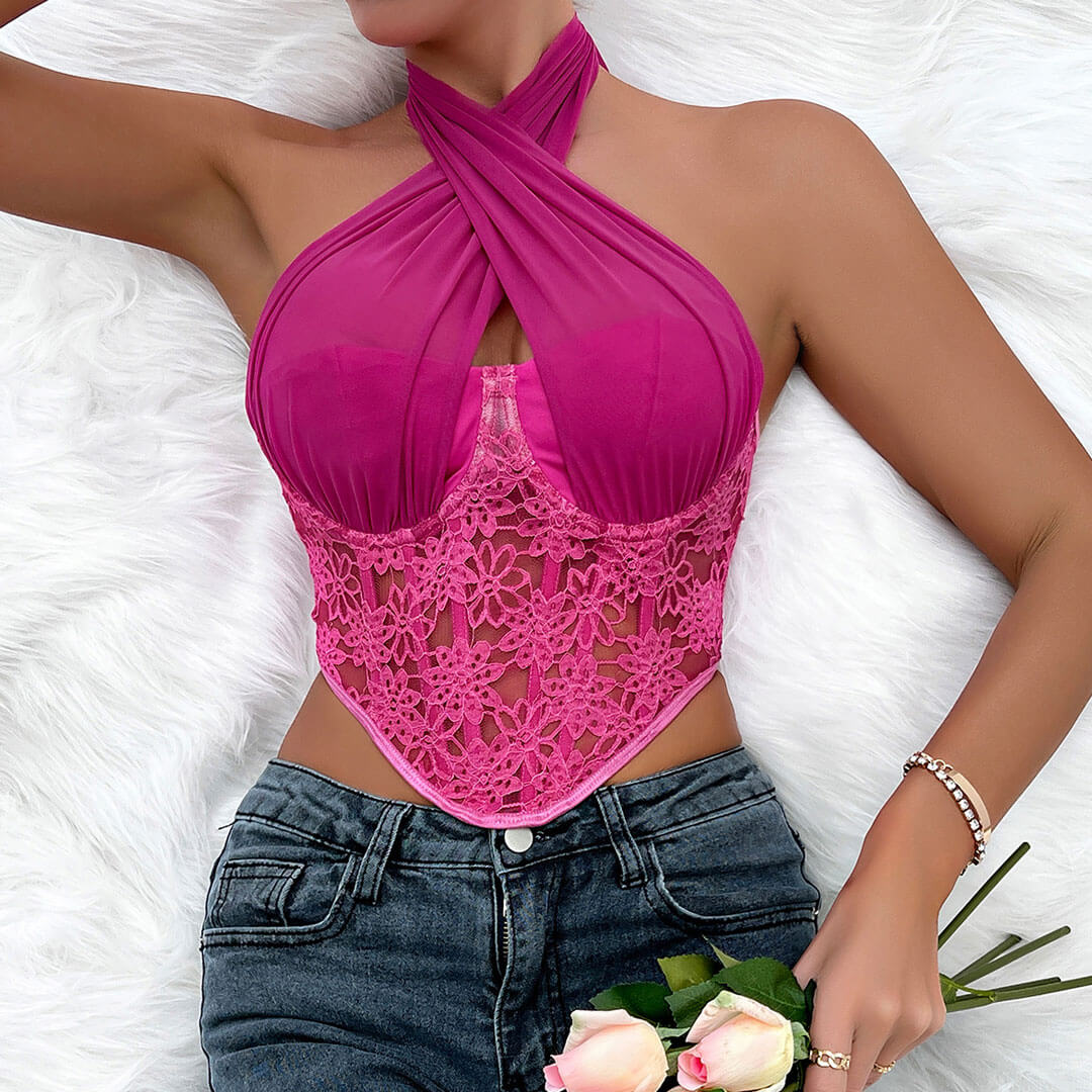 A woman wearing a pink halter top with lace detailing and blue jeans, lying on a white fluffy rug.