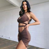 Side view of a woman in a brown halter neck two-piece dress with cut-out details and a ruched skirt.