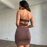 Back view of a woman wearing a brown halter neck two-piece dress with a bodycon skirt.