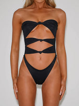 Front view of a woman wearing a black strapless one-piece swimsuit with cut-outs and knot details.