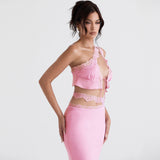 Side profile of a model in a pink one-shoulder lace-trimmed top and skirt.
