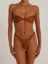 A woman wearing a brown strapless bikini with a knotted bust and high-cut bottoms, front view.