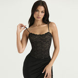 Woman wearing a black lace camisole and black skirt