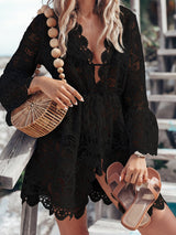 Woman wearing a black lace cover-up with a straw bag and sandals