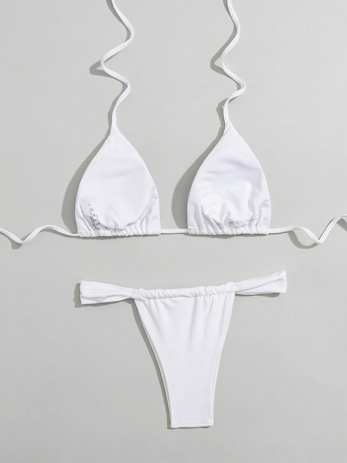 white bikini top and bottom laid out, showing the inside of the top