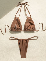 Brown bikini laid out flat on a textured surface with a tag visible.