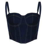 Woman posing in a dark blue denim corset top and denim shorts.