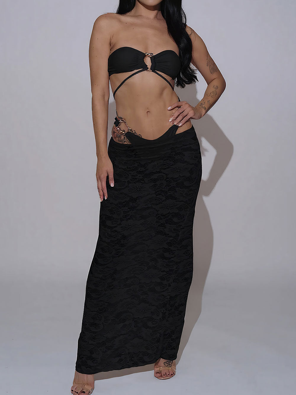 Woman wearing a black bikini with a black lace maxi skirt