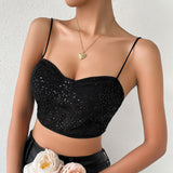 Woman holding pink and white roses while wearing a black sequined corset crop top