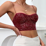 Side view of a woman in a red sequined crop top and white pants, highlighting the fitted silhouette and the detail of the spaghetti straps.