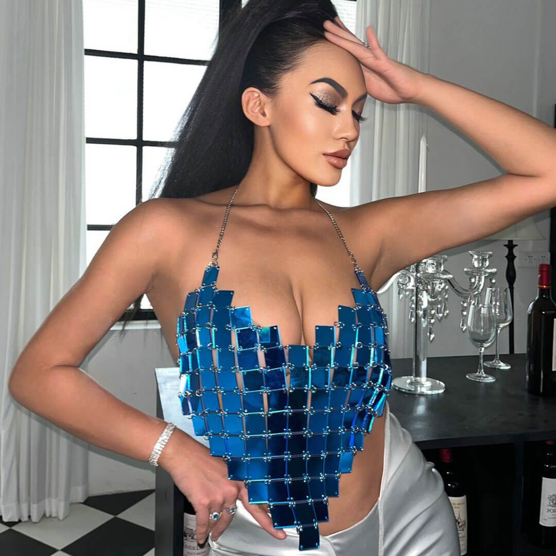 Woman wearing a blue sequined halter top with a heart-shaped design.