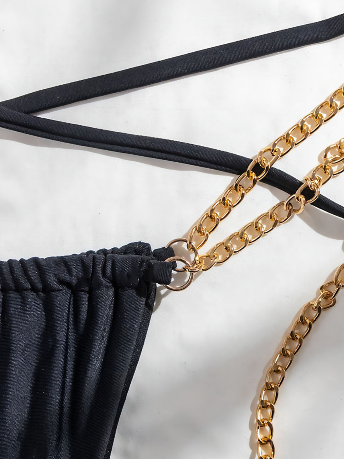 Close-up of the gold chain detailing on the bikini bottom