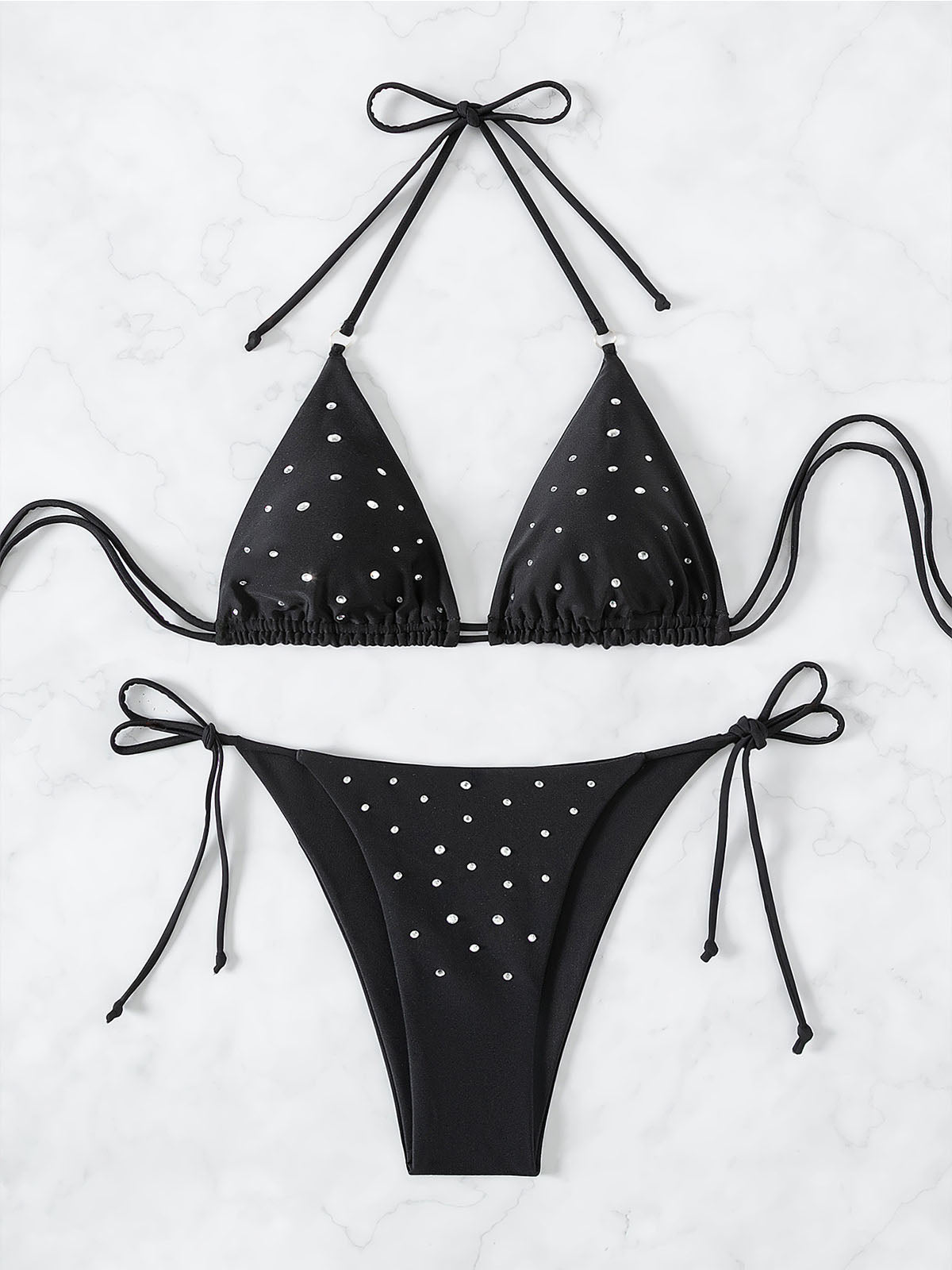 Black bikini top and bottom with silver embellishments laid flat