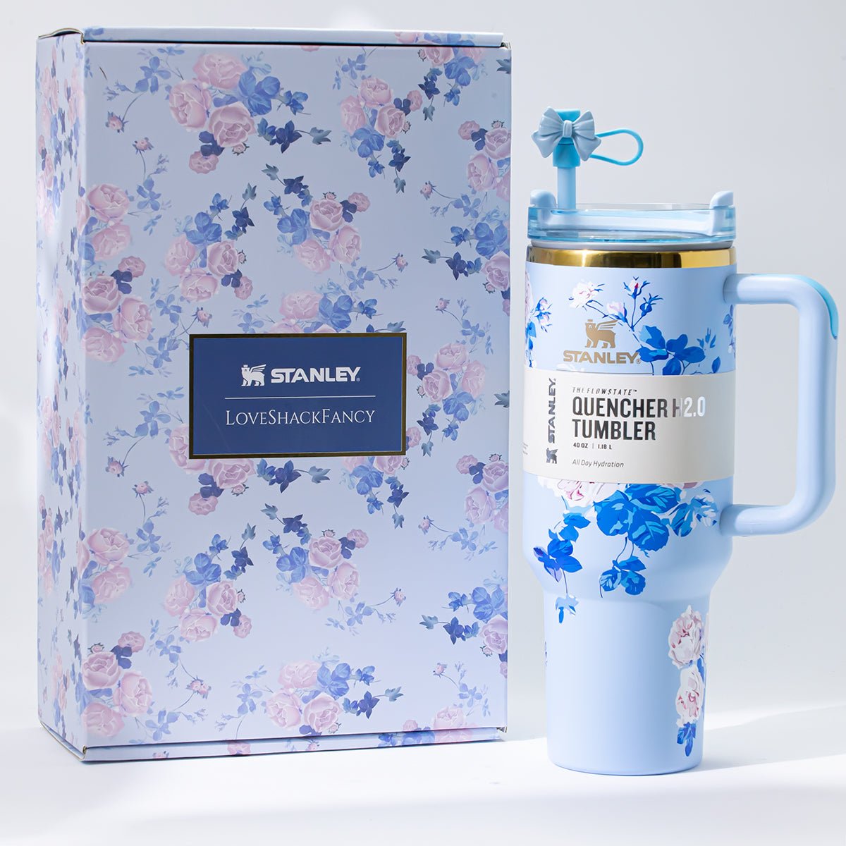 A light blue Stanley Quencher H2.0 Tumbler with a floral design, shown next to its matching floral gift box.