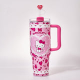 Close-up of pink Stanley tumbler with Hello Kitty graphic and heart pattern, showing the lid and straw