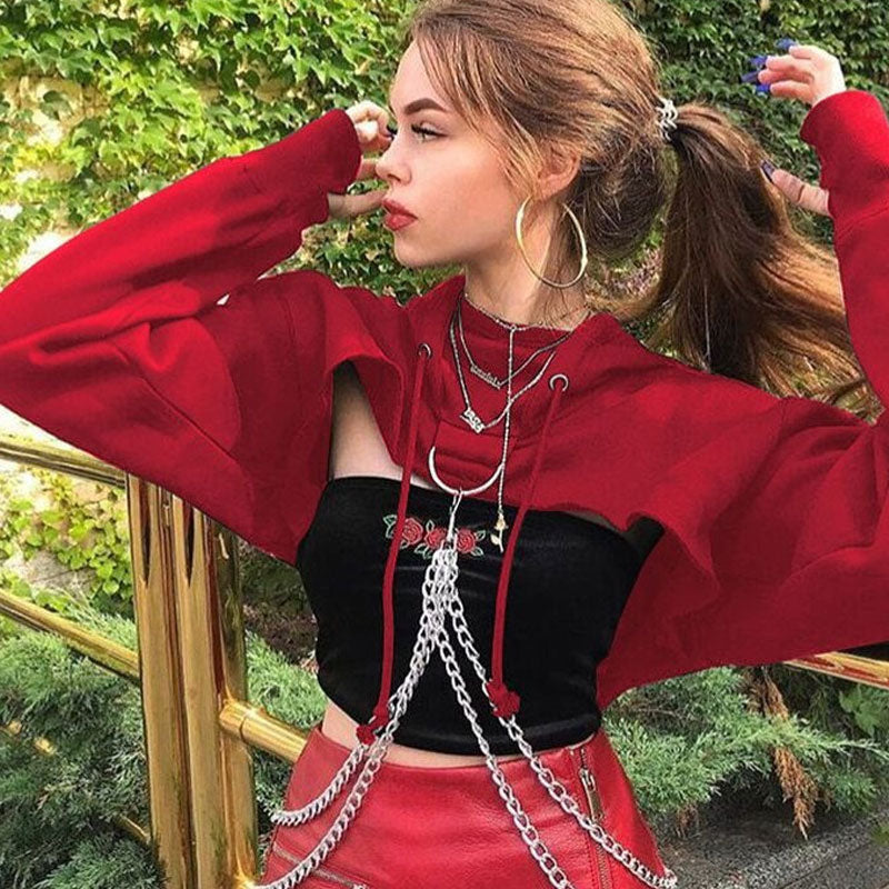 woman wearing a red cropped hoodie with chains over a black tube top and red skirt