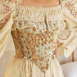 Close-up of a woman wearing a cream blouse with lace trim and a floral corset with ribbon lacing.