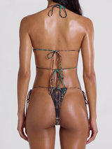 Back view of a woman wearing a brown and teal patterned bikini with string ties.