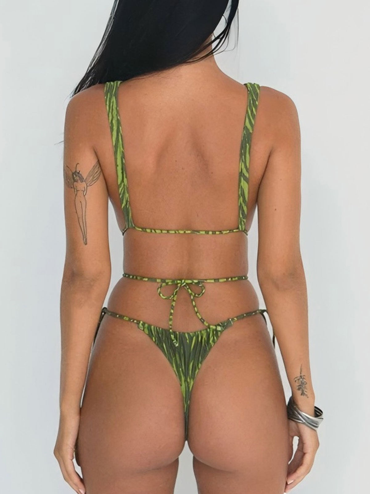 woman in a green and black striped bikini from the back