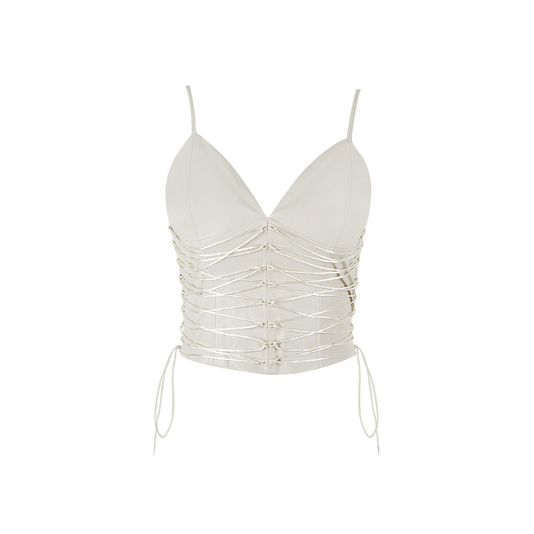 Product shot of the cream sleeveless V-neck top with ruched detailing and lace-up accents against a white background.