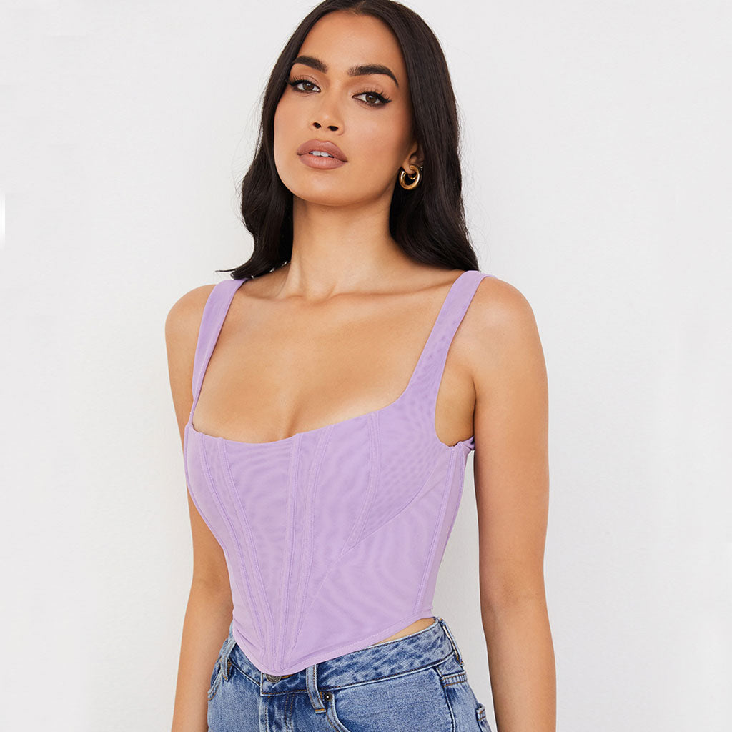 woman wearing a purple corset top and blue jeans, front view
